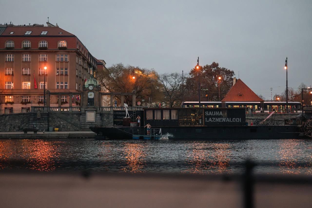 Loď Lázně na Lodi večer na Vltavě, host skáče do řeky